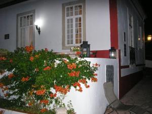 une maison blanche avec une brousse et des fleurs orangées dans l'établissement Quinta de Sao Filipe, à Setúbal