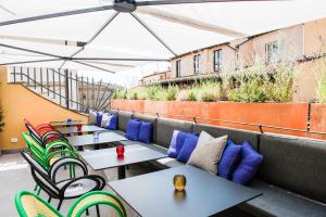 una fila de mesas y sillas en un patio de la azotea en Hotel Milu Florence, en Florencia