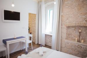 Zimmer mit einem Schreibtisch und einem TV an der Wand in der Unterkunft Barone Room in Šibenik