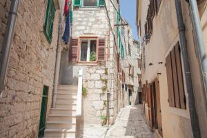 eine Gasse in einer Altstadt mit Treppen in der Unterkunft Barone Room in Šibenik