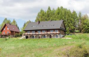 una grande casa in legno su una collina in un campo di Cudne Manowce a Wetlina