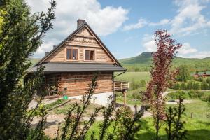 una casa di legno in mezzo a un campo di Cudne Manowce a Wetlina