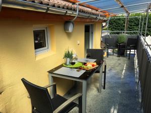 a table with a bowl of fruit on it on a patio at Ferienhaus Zur Mainpforte in Mainz