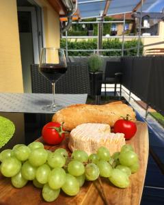 a wooden cutting board with grapes and a glass of wine at Ferienhaus Zur Mainpforte in Mainz