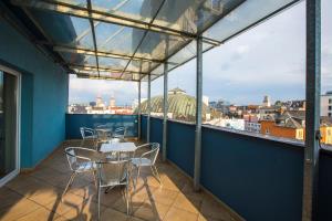 balcone con tavoli, sedie e vista sulla città di Hotel Trend a Plzeň