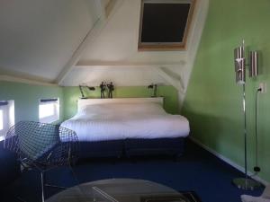 una piccola camera con un letto in una stanza verde di Appartement Sint Jan a Den Bosch