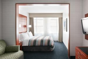 une chambre d'hôtel avec un lit et une chaise dans l'établissement Central Loop Hotel, à Chicago