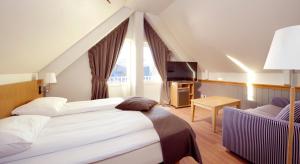 A bed or beds in a room at Clarion Collection Hotel With