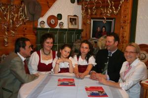 un grupo de personas sentadas en una mesa en Landgasthof Hubertusstubn, en Sankt Michael im Lungau