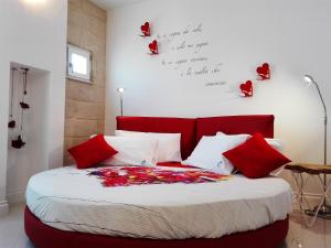 una camera da letto con un letto rosso con rose sul muro di Corte del Pascià a Lecce