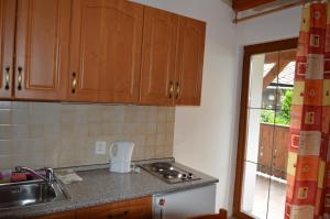 a kitchen with wooden cabinets and a sink and a window at Apartmány U Vaců in Železná Ruda