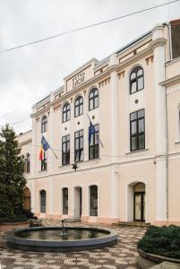 a large building with flags in front of it at Hotel Dacia in Lugoj