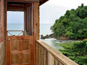 una porta aperta su un balcone con vista sull'oceano di SeaScape on Heavenly Bay a Castara