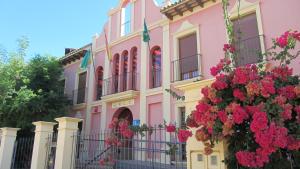 un edificio rosa con dei fiori di fronte di Hotel Pinomar a El Puerto de Santa María