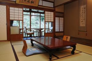 una camera con tavolo, sedie e finestre di Iwaso a Miyajima