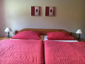 - une chambre avec 2 lits avec des draps roses et 2 lampes dans l'établissement Pension Villa Strandläufer, à Norddeich