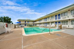 a hotel with a swimming pool in a courtyard at Avera Suites in Muskogee