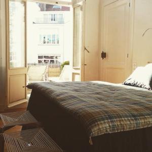 - une chambre avec un lit et une grande fenêtre dans l'établissement Maison Flagey Brussels, à Bruxelles