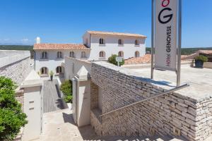 un bâtiment avec un panneau à côté d'un mur de briques dans l'établissement Hotel Spa Genovese, à Bonifacio