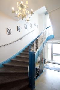 a blue and white staircase with a chandelier at Hotel Neun 3/4 in Celle