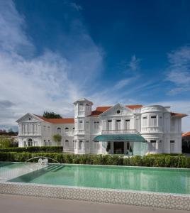 uma grande mansão branca com uma piscina em Macalister Mansion em George Town