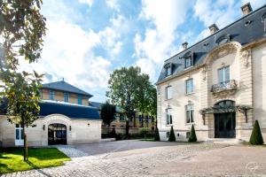 a large white building with a blue roof at Les Suites du Champagne de Venoge in Épernay