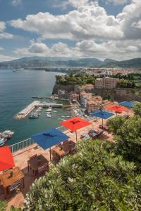 vista su un porto con tavoli e ombrelloni di Maison La Minervetta a Sorrento