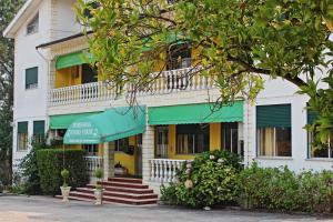 um edifício amarelo e branco com um toldo verde em Residencial Pinho Verde na Mealhada