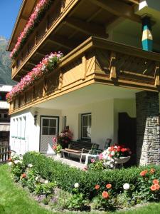 a house with a balcony with flowers on it at Haus Kristall in Längenfeld