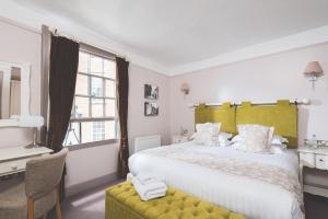 - une chambre avec un grand lit et une tête de lit jaune dans l'établissement The Globe, à Exeter