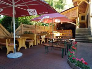 un patio con mesas, sillas y una sombrilla en Hotel - Restaurant Sophienaue, en Eisenach