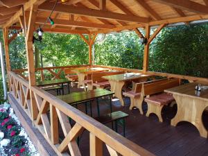 una terraza de madera con mesas y bancos en un pabellón en Hotel - Restaurant Sophienaue, en Eisenach