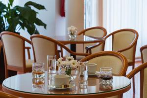 a table with glasses and flowers on top of it at Hotel Rotondo in Trogir