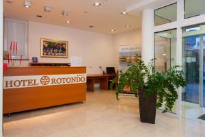 a hotel rotonda lobby with a reception desk and plants at Hotel Rotondo in Trogir