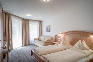 een hotelkamer met een bed en een bank bij Alpenresidenz am Mühlbach in Obergurgl