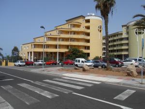 una strada vuota con auto parcheggiate di fronte a un edificio di Orlando Apart ad Adeje