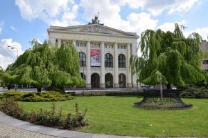 un grande edificio bianco con alberi di fronte di Kampus Palace a Ostrava