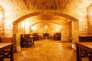 una sala da pranzo con tavoli e sedie in un muro di mattoni di London Rooms Zagreb Airport a Velika Gorica