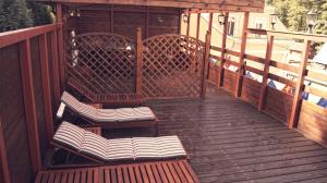 deux bancs assis sur une terrasse en bois dans l'établissement Hotel St.Michael, à Karlovy Vary