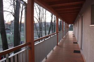 a porch with a wooden walkway with a view of the water at Teke Bowling Centrum és Sport Panzió in Szeged