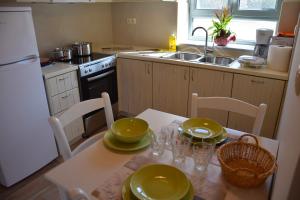 a kitchen with a table with green dishes on it at Kastro-Kardamili in Kardamili