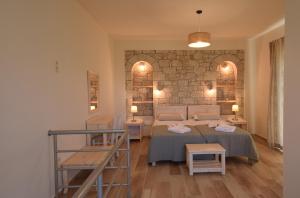 a bedroom with two beds and a stone wall at Kastro-Kardamili in Kardamili