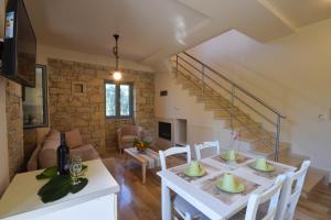 a kitchen and living room with a white table and chairs at Kastro-Kardamili in Kardamili