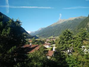 uma vista para uma aldeia nas montanhas em Hotel Rogen em Neustift im Stubaital