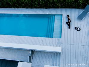 una persona in piedi sul lato della piscina di Hotel Nettuno a Cala Gonone