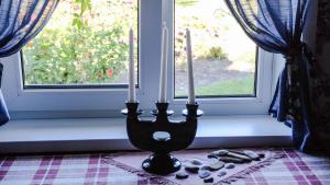 un candelabro con tres velas en una ventana en Coastal Home Muini Ūši, en Kolka