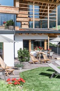 een patio met stoelen en tafels op een huis bij Chalet Sophia in Ortisei