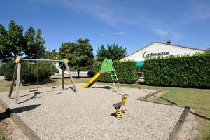 um parque infantil com um escorrega e uma bandeira verde em Campanile Valence Sud em Valence