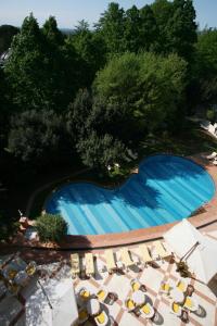 una vista sul soffitto di una piscina con sedie e alberi di Grand Hotel Bellavista Palace & Golf a Montecatini Terme