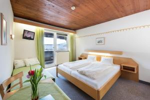 1 dormitorio con cama, mesa y ventana en Hotel Linde, en Wörgl